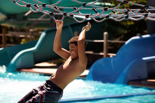 Boy going across lily pads at Cove Point Pool