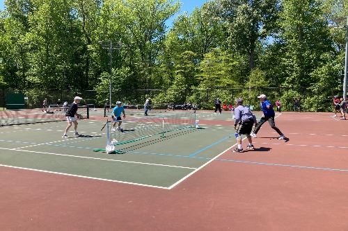 Four men playing pickleball