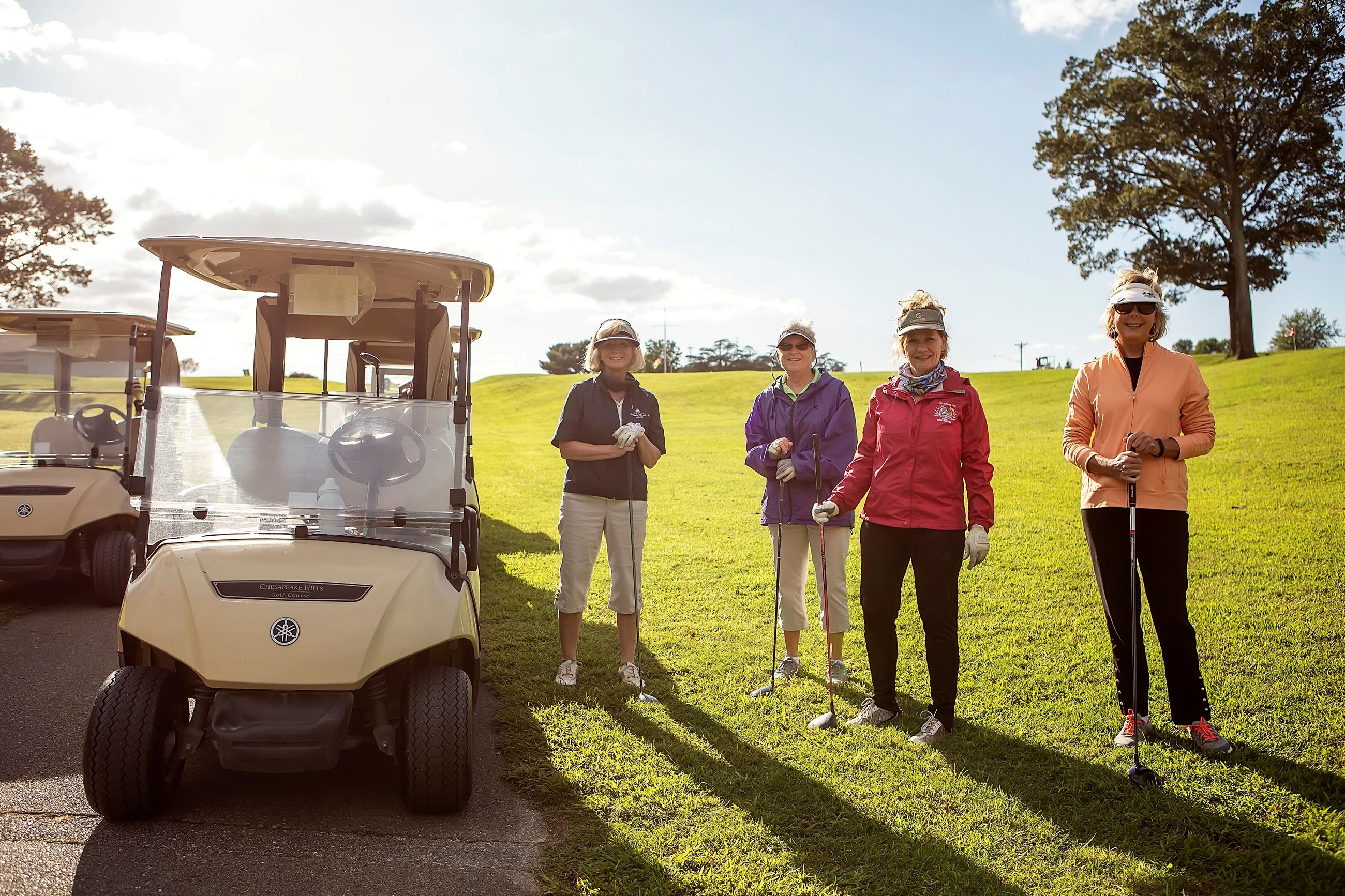 Four women next to a golf course