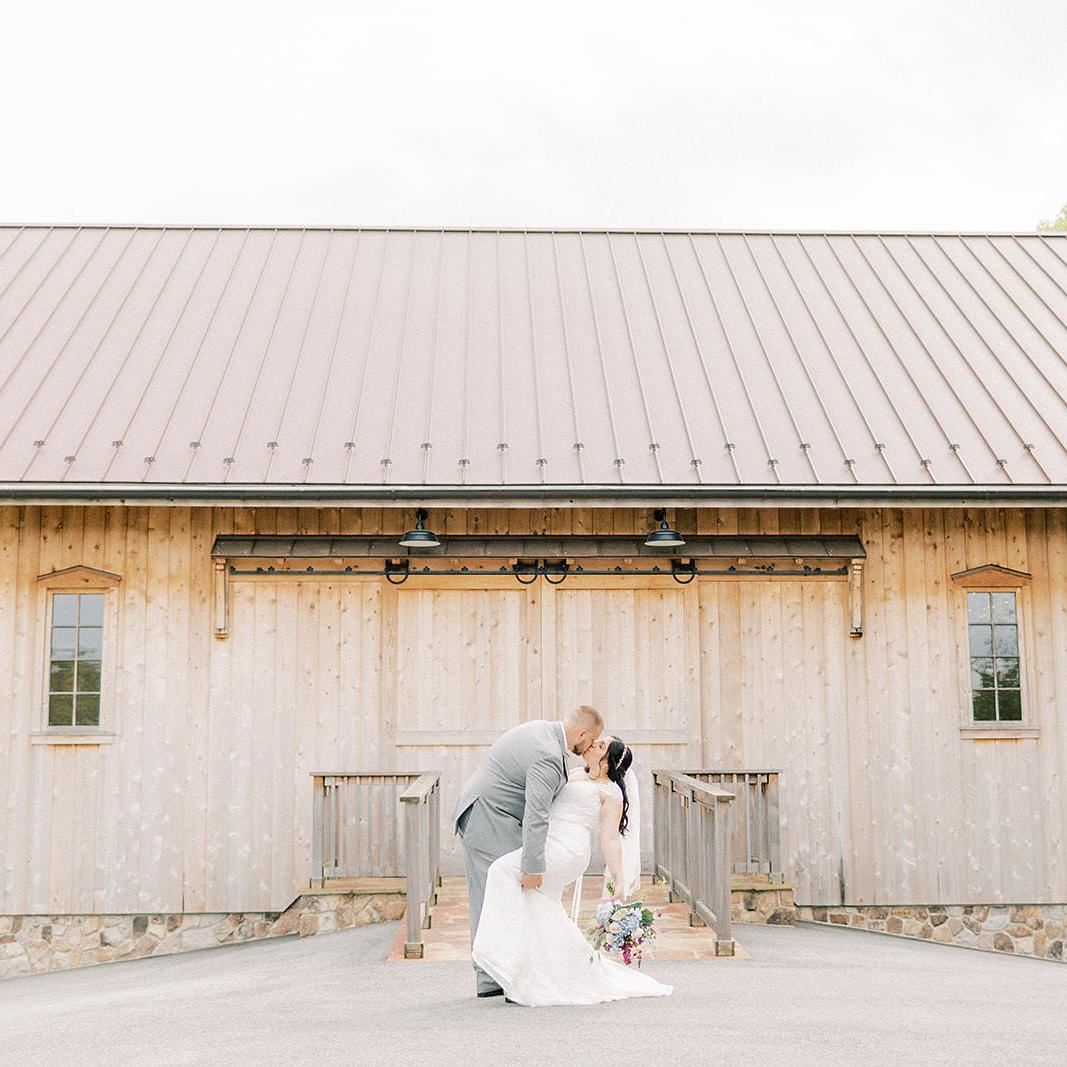 Bride and groom inside under a fabric arch with flowers