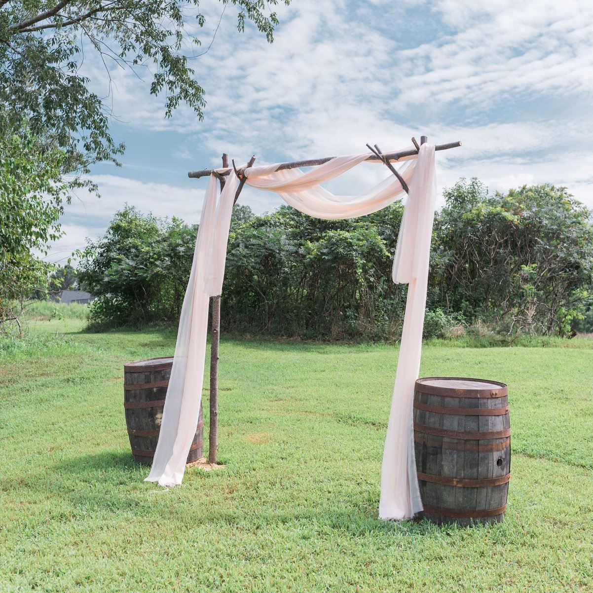 Archway outdoors with wine barrels and fabric blowing in the wind