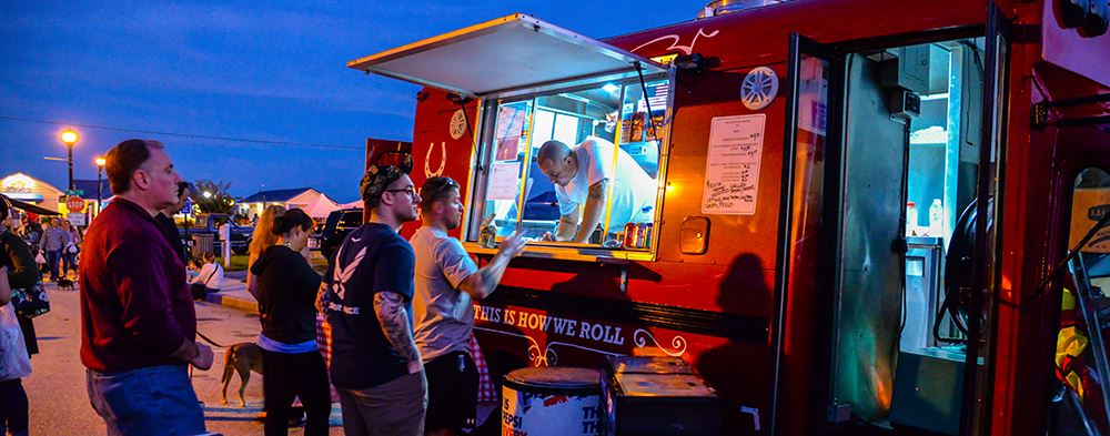 Man serving food in yellow food truck