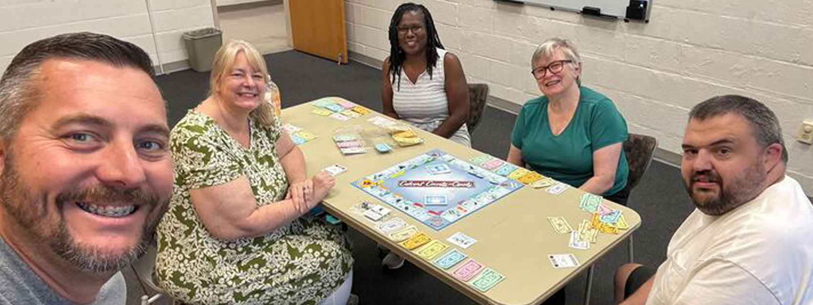Men and women around a table playing a board game
