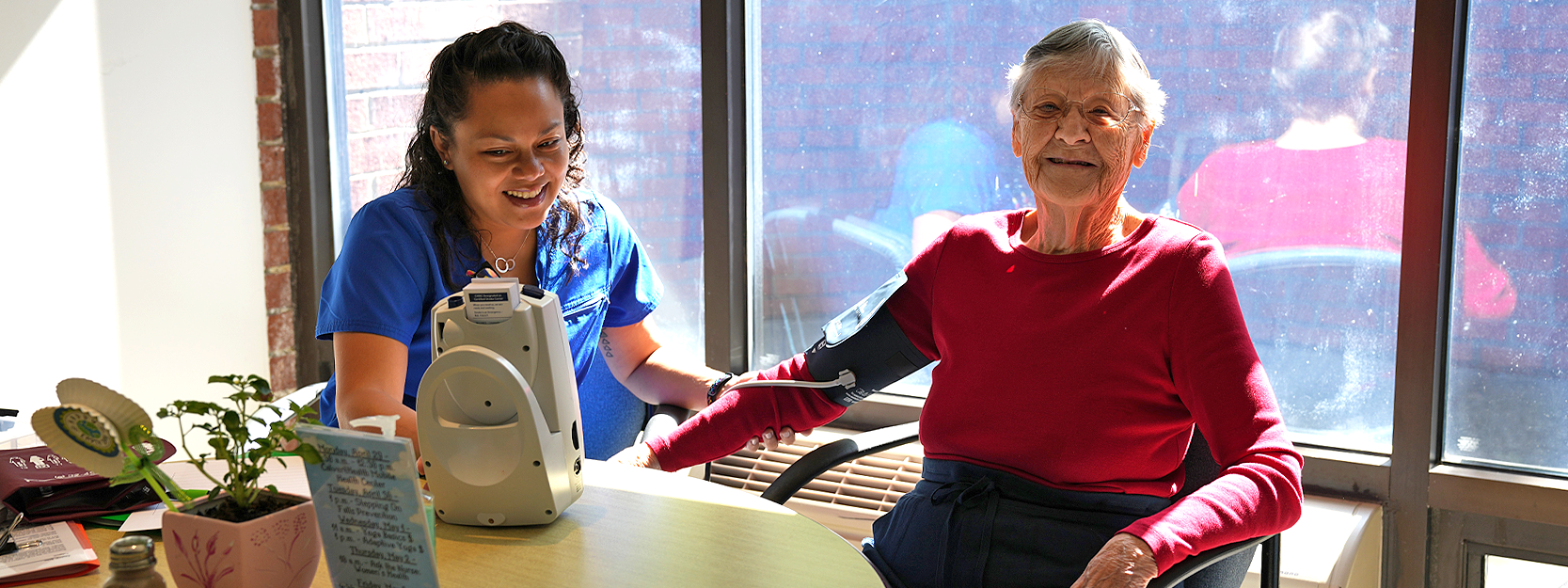 nurse with a woman with a blood pressure cuff